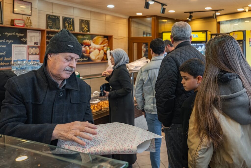 Customers waiting in line at a bakery counter