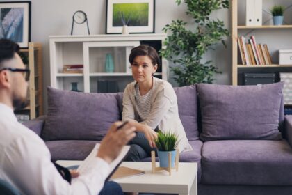 a man sitting on a couch talking to a woman