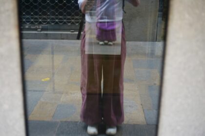 Reflection of a person wearing purple pants in a mirror.