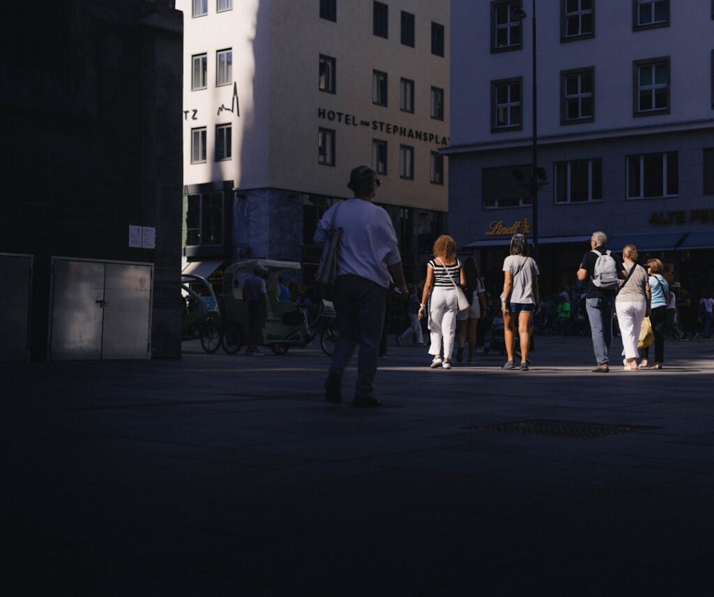 People walking on a sunlit city street.