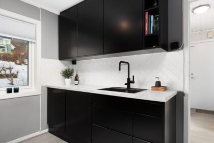 A kitchen with black cabinets and white counter tops