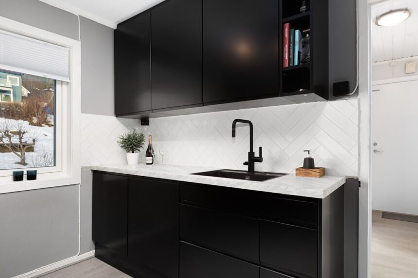 A kitchen with black cabinets and white counter tops