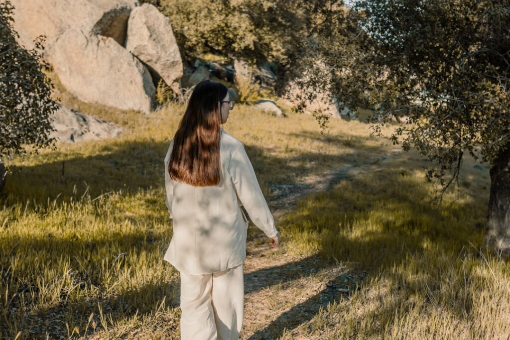 a woman walking down a path in a field
