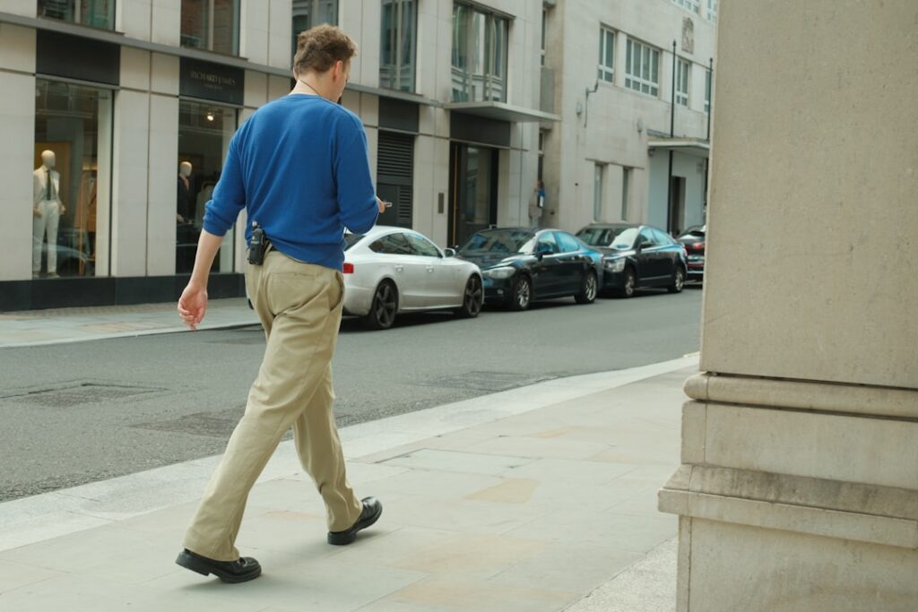 a man walking down the street in a blue sweater