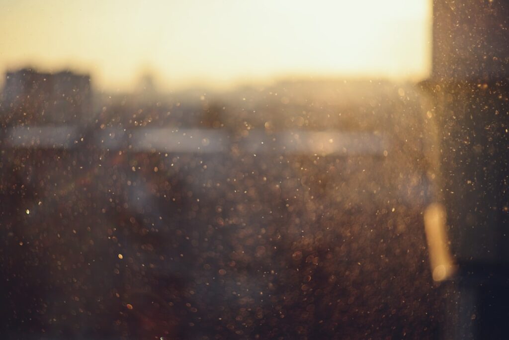 Dust particles floating in sunlight near buildings