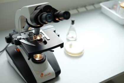 A microscope sitting on top of a table next to a bottle