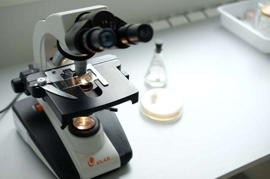 A microscope sitting on top of a table next to a bottle