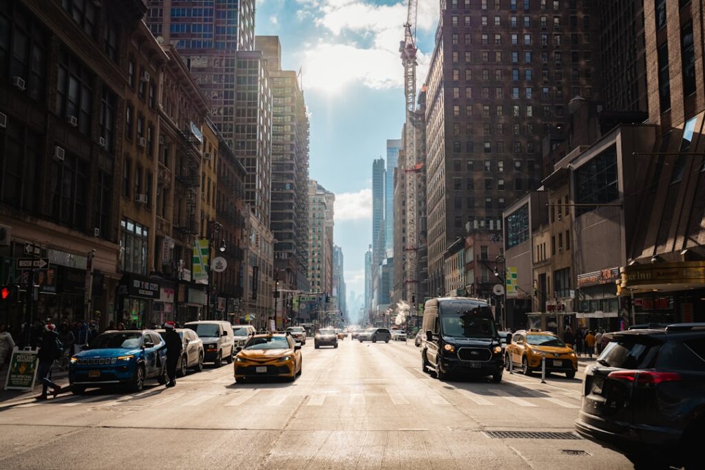 City street lined with tall buildings and traffic.