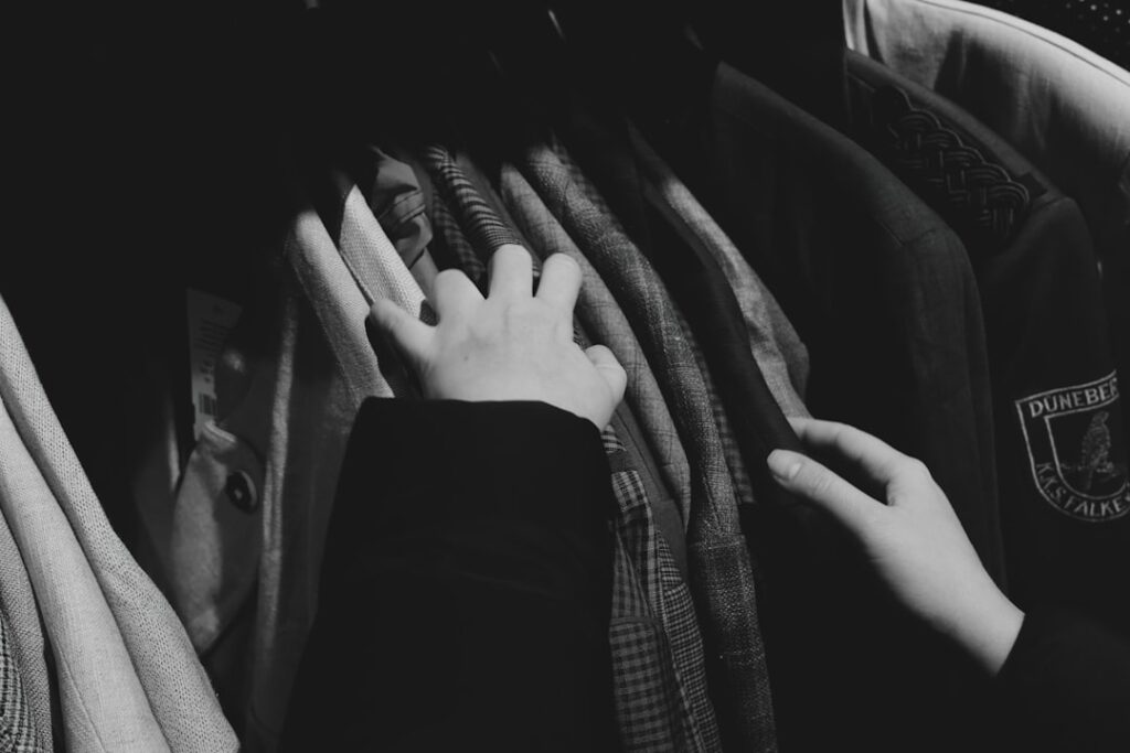 Hands browsing through a rack of clothes