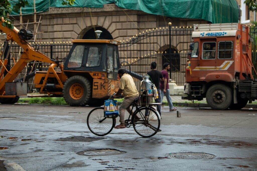 Man rides a bicycle in a street with vehicles.