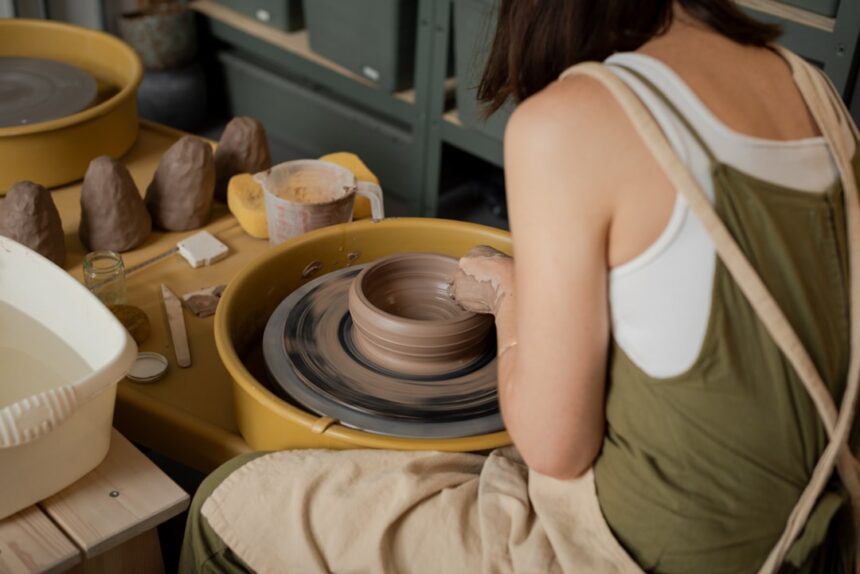 Woman shaping clay on a pottery wheel