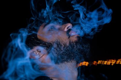 man in black shirt smokes