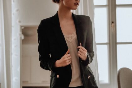woman in black blazer standing near white wall