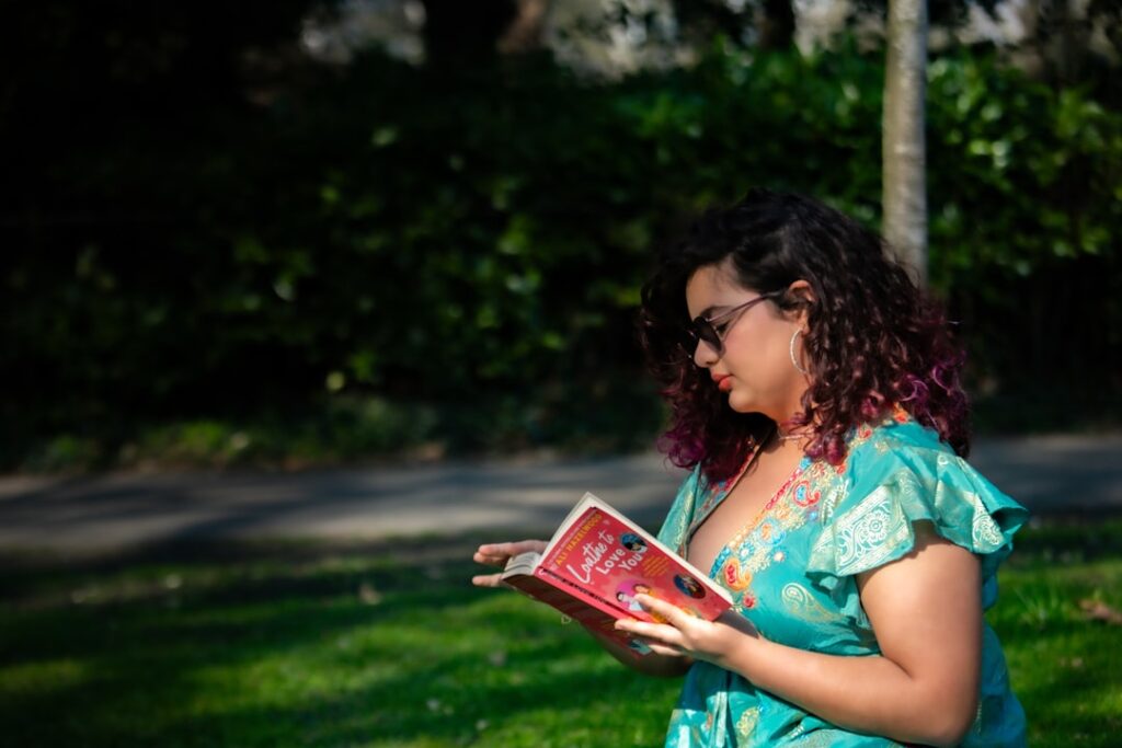 A woman reading a book in a park.