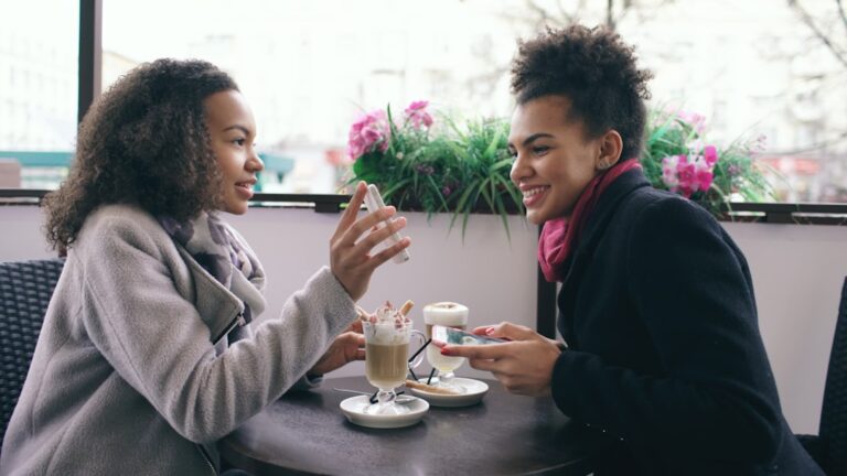 Two women talking at a cafe with drinks