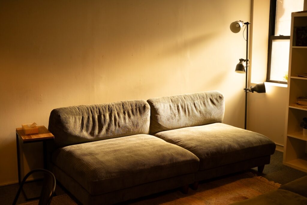 A comfortable sofa bathed in warm lamp light.