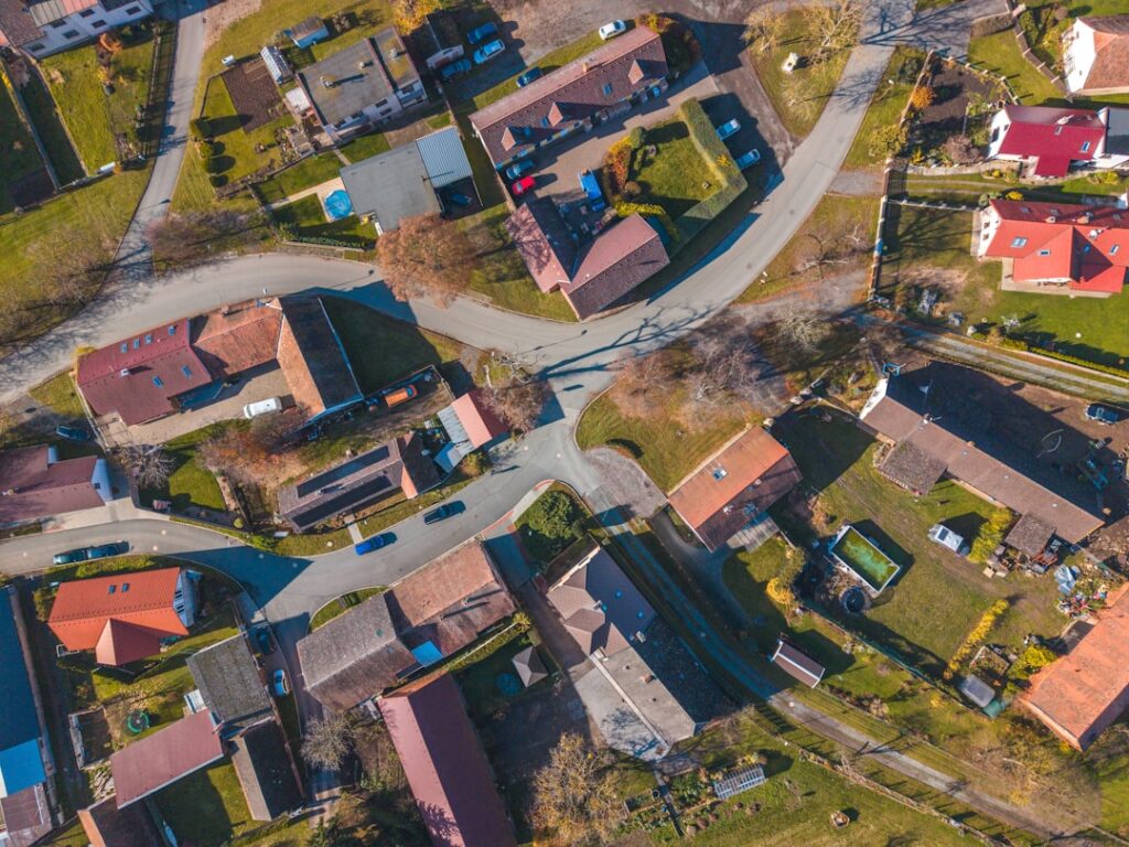 Aerial view of a village with winding roads and houses.