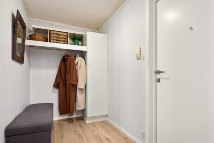 A walk in closet with a bench and coat rack