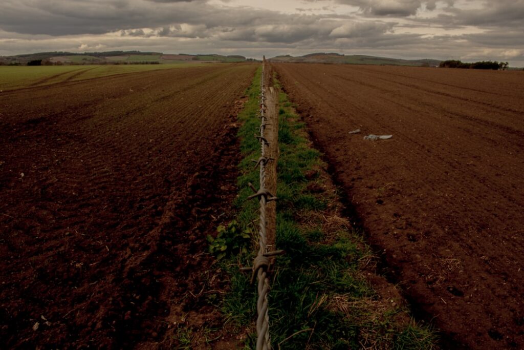 a field with a fence in the middle of it