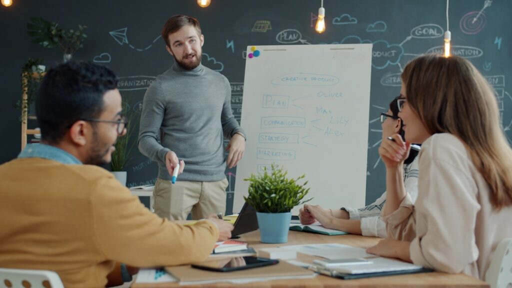 Team collaborating around a whiteboard during a meeting.