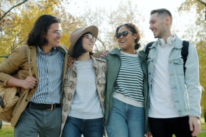 Four friends walking together in a park