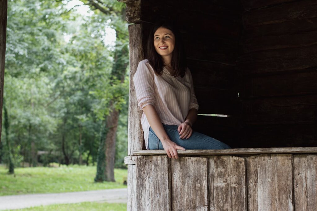 a woman is sitting in a wooden structure