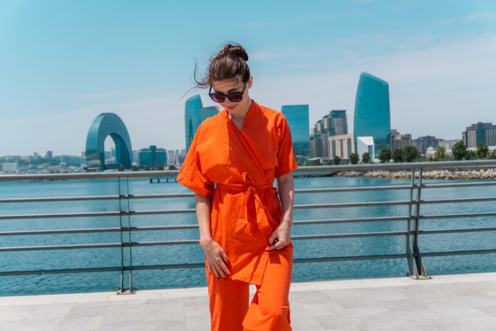 Woman in orange jumpsuit with cityscape background