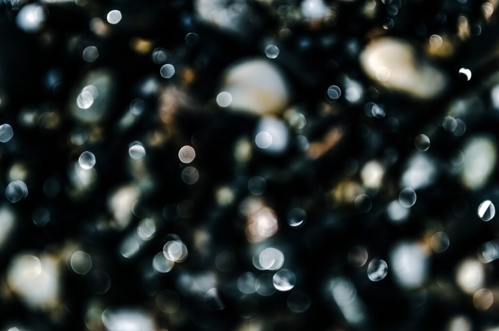 Close-up of dark gravel with water droplets.